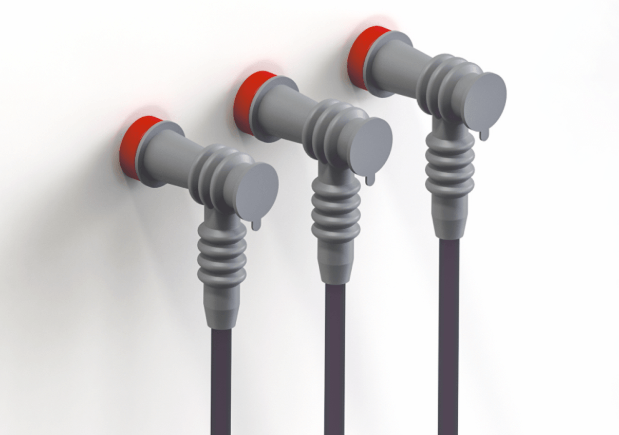Three grey ribbed elbow terminal protectors fitted over red bushings, each with a small hinged cap covering a test point, cable entering from below