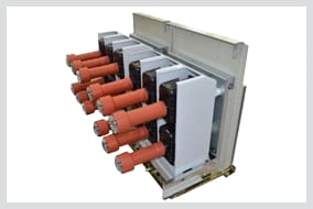Withdrawable switchgear truck with orange insulation boots fitted over each of its six contact arms